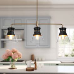 three lights hanging over a kitchen island in a home