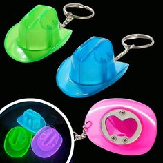 three different colored hats shaped keychains on a black background, one with a heart in the middle