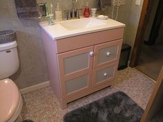 a bathroom with a sink, toilet and mirror on the wall next to a door