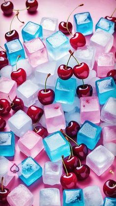 ice cubes and cherries are arranged on a pink surface