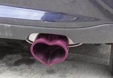 the rear end of a car with a heart shaped exhaust pipe