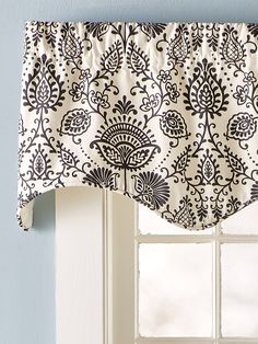 a window with a black and white curtain hanging from it's side