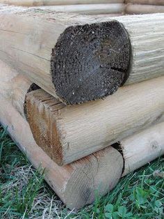 two pieces of wood stacked on top of each other in front of grass and logs