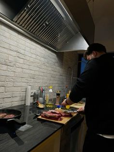 a man standing in front of a stove preparing food