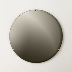 a round mirror hanging on the wall above it's head, with metal studs at the bottom