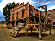 an old wooden building with stairs leading up to the upper level and second story area