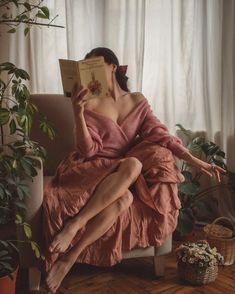 a woman sitting in a chair reading a book