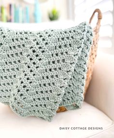 a crocheted blanket sitting on top of a white chair