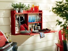 a red shelf with utensils and plates on it