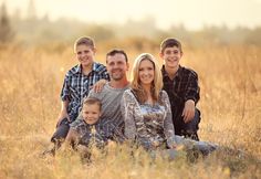 a family is sitting in the tall grass