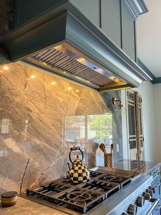 a stove top oven sitting inside of a kitchen next to a wall mounted range hood