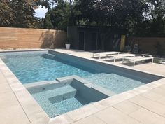 an empty swimming pool with lounge chairs around it