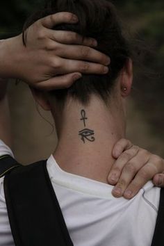 a woman with a tattoo on her neck holding her head in front of her face