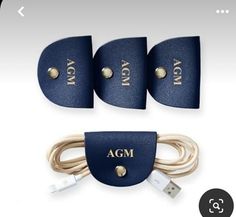 three pieces of blue leather with gold letters on them and two cords connected to each other