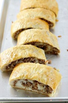 some meat filled pastries are on a baking sheet