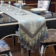 the table is set with two place settings and one has a silver tassell on it