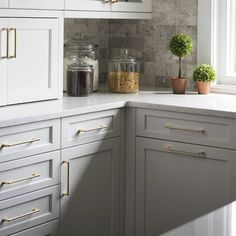 a kitchen with white cabinets and gold pulls on the handles is pictured in this image