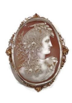 Magnificent That is the only word to describe this outstanding pin/pendnat. The cameo is ornately hand carved with no chips or breaks. The cameo depicts a woman with long flowing hair with flowers. The entire pin including frame measures approximately 4 inches! The cameo is from the late 1800's however I believe the 14 karat yellow gold frame was made slightly later...perhaps around the early to mid 1900's. On the back of the frame the pendant attachment can be swiveled down so as not to be seen Ornate Oval Carved Brooches, Ornate Carved Oval Brooches, Ornate Carved Collectible Brooches, Hair With Flowers, Antique Amethyst Ring, Amethyst Ring Vintage, Victorian Cameo, Seed Pearl Ring, Flowing Hair