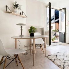 a table with two chairs and a potted plant sitting on top of it next to a window