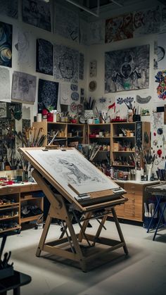 an artist's studio with lots of art work on the walls and desks