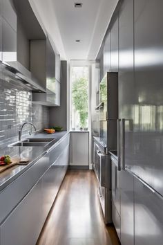 Sleek, modern kitchen with stainless steel appliances and glossy gray cabinets, featuring a tall window with natural light. Small Galley Kitchen Ideas, Small Galley Kitchen Designs, Galley Kitchen Ideas, Galley Kitchen Layout, Small Galley Kitchen, Galley Kitchen Design, Small Kitchen Design, Industrial Chic Style, Galley Kitchens