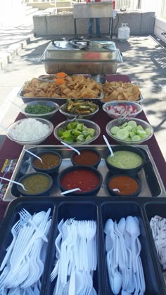 a buffet table filled with different types of food and utensils on trays