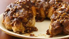 a bundt cake with chocolate frosting and nuts on top sits on a plate