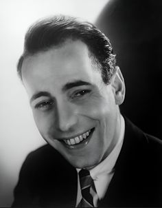 a black and white photo of a man in a suit with a smile on his face