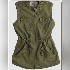 Route 66 Outdoor Cargo Vest Nwt Size M 100% Cotton Fabulous 90’s Safari Vest In A Very Rich Olive Green. Stand Up Ruffle Collar Detail Sets This One Apart. Zip Closure. Upper Front Snap Flap Pockets. Lower Slash Pockets With Snap Flap Detail. Drawstring Waist. Bronze Hardware. Hi/Lo Hem With Split Rivet Detail.#Vintage #Layering #Safari #Utility #Eclectic #Unique #Adventure #Travel Khaki Cargo Pocket Top For Spring, Casual Workwear Vest With Cargo Pockets, Cotton Military Tops For Outdoor Activities, Military Tops With Pockets For Outdoor Activities, Fall Military Tops With Pockets, Military Tops With Pockets For Fall, Military Style Tops With Pockets For Fall, Casual Olive Cotton Utility Jacket, Khaki Tops For Outdoor Activities In Fall