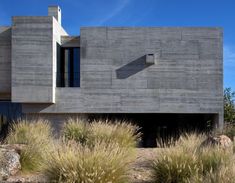 a large concrete building sitting next to tall grass