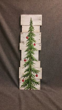 a christmas tree made out of pallet wood with ornaments on the top and bottom