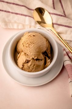 two scoops of ice cream in a white bowl on a pink and white towel