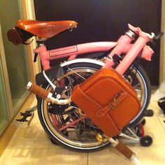 a pink bicycle with a brown bag on it