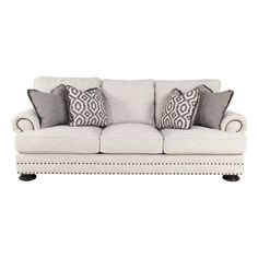 a white couch with pillows on it and some black and white throw pillows in the back