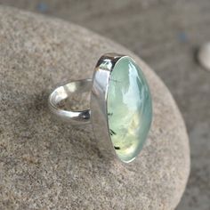 Natural Prehnite Ring, Oval Prehnite Gemstone Ring, 925 Sterling Silver Ring, Birthstone Ring, Artisan Handmade Gift Ring, Prehnite Jewelry Green Prehnite helps you to connect to beings on the higher spiritual planes, and enhances spiritual growth. This lovely stone has an energy that helps you to be prepared, as it enhances precognition or prior knowledge of an event, and the gift of prophecy. By its action of linking your heart with your will, by its vibration within the solar plexus, it assis Green Oval Moonstone Gemstone Ring, Oval Green Moonstone Gemstone Ring, Green Oval Moonstone Ring, Green Oval Moonstone Ring In Sterling Silver, Green Oval Prehnite Rings, Peach Morganite Ring, Peach Morganite, Jasper Ring, Cushion Cut Ring