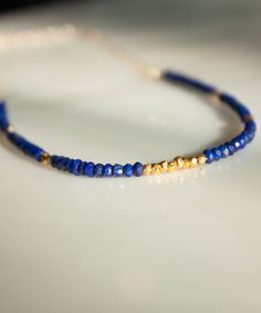 "Rows of faceted Lapis and glimmering Vermeil nuggets are artfully arranged with our Lyra Banded Gemstone Necklace. Perfect as a delicate solo piece or as a touch of color to add to your layers. The Lyra Necklace is currently available in Garnet, Lapis and Turquoise. If you would like to custom order this style in a different gemstone, please feel free to get in touch. We'd love to make it for you! DETAILS » Measurements: 16-19\" adjustable length » Materials: Lapis Faceted Gemstones | Vermeil a Adjustable Faceted Rondelle Beads Jewelry, Adjustable Rondelle Faceted Bead Jewelry, Briolette Polished Beads Jewelry Gift, Lapis Lazuli Beaded Necklace With Faceted Beads For Gift, Dainty Jewelry With Faceted Beads For Jewelry Making, Faceted Sapphire Beaded Necklace Gift, Sapphire Faceted Beaded Necklace For Gift, Elegant Sapphire Faceted Beaded Necklaces, Lapis Lazuli Rondelle Gemstone Beads Jewelry