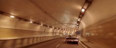 two cars driving through a tunnel with lights on