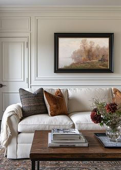 a living room filled with furniture and a painting on the wall above it's coffee table