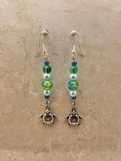 Turtle Dangle Earrings with Glass, Stone and Stainless Steel Hooks Casual Single Dangle Earring, Casual Green Dangle Jewelry, Casual Green Dangle Earrings, Casual Green Drop Earrings, Wire Turtle Earrings, Ocean-inspired Single Dangle Earring, Glass Dangle Earrings For The Beach, Ocean-inspired Dangle Charms Jewelry, Cartiloge Earring Turtle