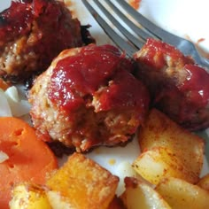 meatballs and vegetables on a plate with a fork