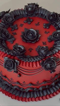 a red and black cake with roses on it