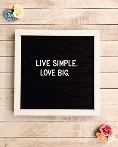 a black and white framed sign with the words live simple love big written on it