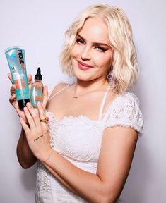 a woman is holding two bottles of hair products in one hand and an empty bottle in the other