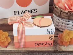 a gift box with a ribbon tied around it sitting on a table next to flowers