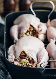 raw chickens are being cooked in a roasting pan