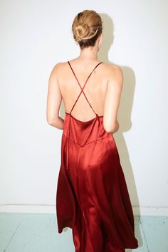 Slip dress that can be adjusted by knotting the straps in a loop at the back. Can be straight or crossed. Interior waist front ties to adjust to the fit the waist Silk bias finishes on neckline and armholes French seaming Colour: Ruby Red One size fits all (S/M/L) 100% Pure Silk. SatinMADE IN NEW YORK CITY Red Sleeveless Tie-back Backless Dress, Red Sleeveless Backless Dress With Tie Back, Red Sleeveless Backless Dress, Red Backless Dress With Tie Back, Red Dress With Tie And Strappy Back, Red Sleeveless Backless Dress With Back Opening, Cross Back Tie Dress For Date Night, Tie Back Cross Back Dress For Date Night, Red Spaghetti Strap Backless Dress For Date Night