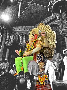 an artistic photo of two men sitting on the back of a statue in front of a crowd