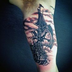 a man with a ship tattoo on his arm