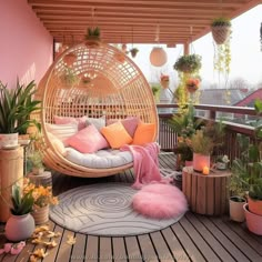 a balcony with lots of potted plants and hanging chairs on the deck, including a hammock chair