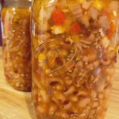 two jars filled with food sitting on top of a wooden table